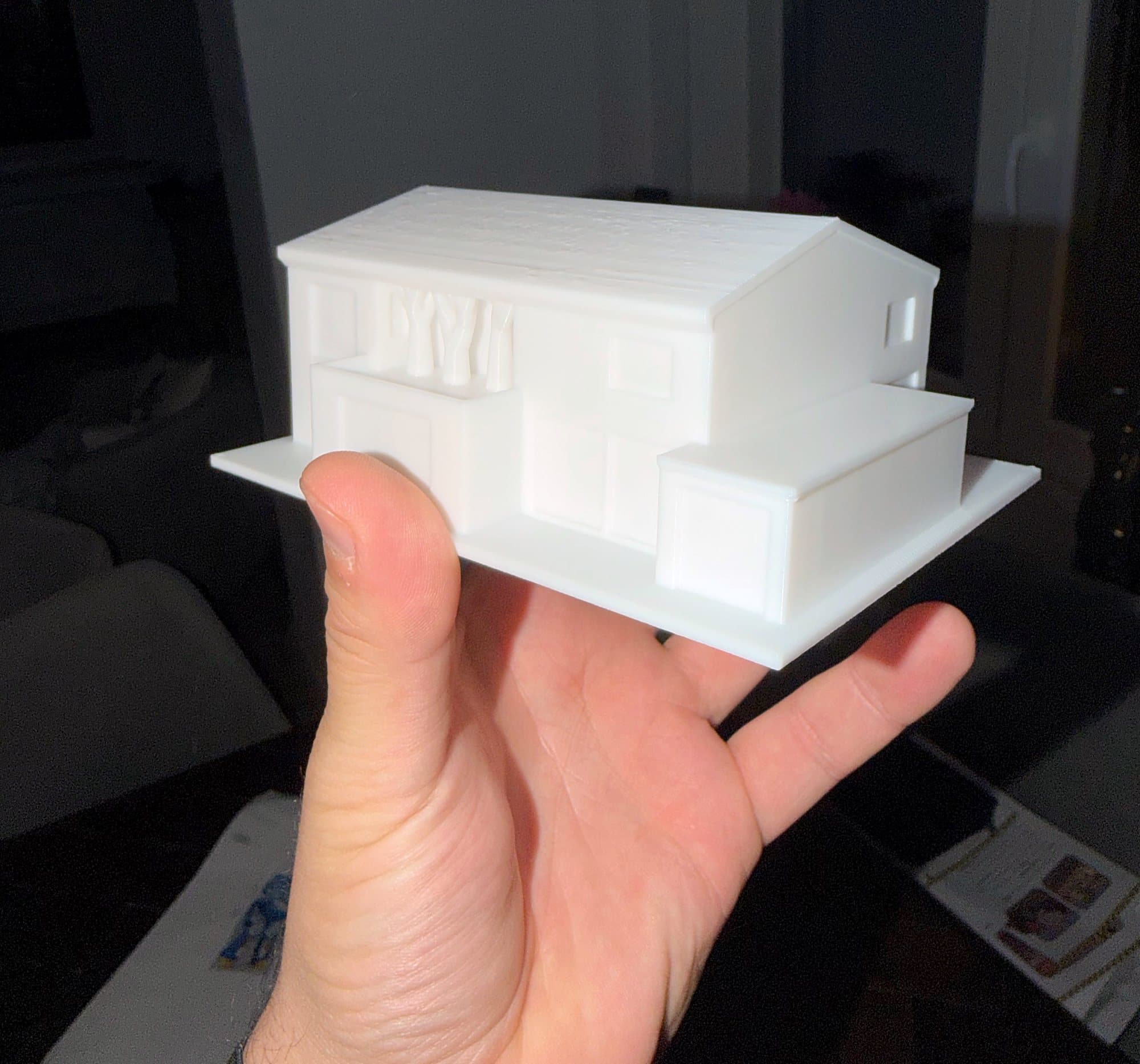 Testdruck eines weißen Architekturmodells in einer Hand, Rückseite.